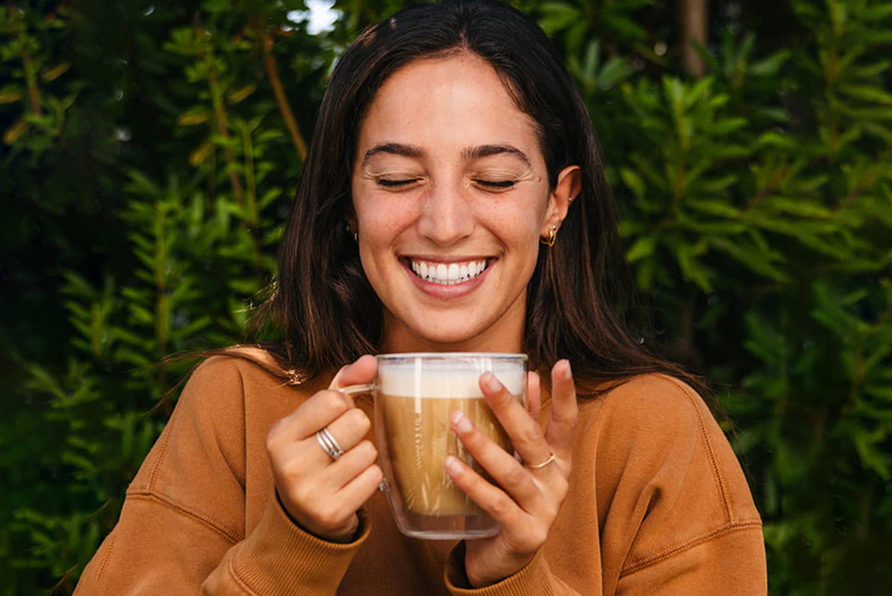 Woman smiling and drinking cup of coffee