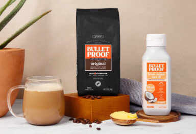 Bulletproof Original Ground Coffee bag, bottle of Brain Octane C8 MCT oil and mug of coffee on kitchen counter with scoop of ghee