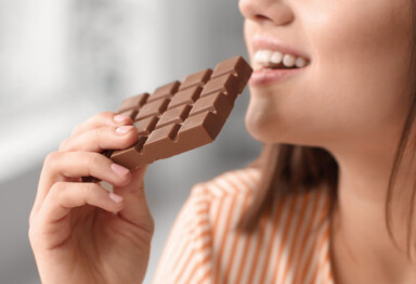 Woman eating a bar of chocolate for gut health