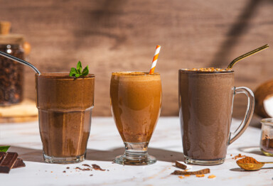 3 different types of chocolate coffee collagen smoothies in glass jars with straws