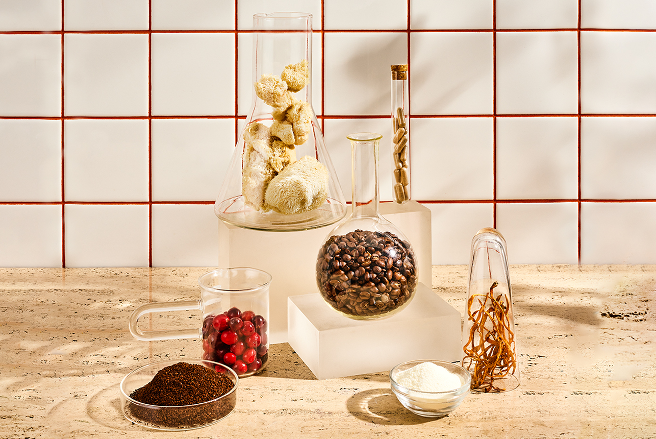 Coffee beans, lion's mane mushrooms and supplement capsules in test tubes