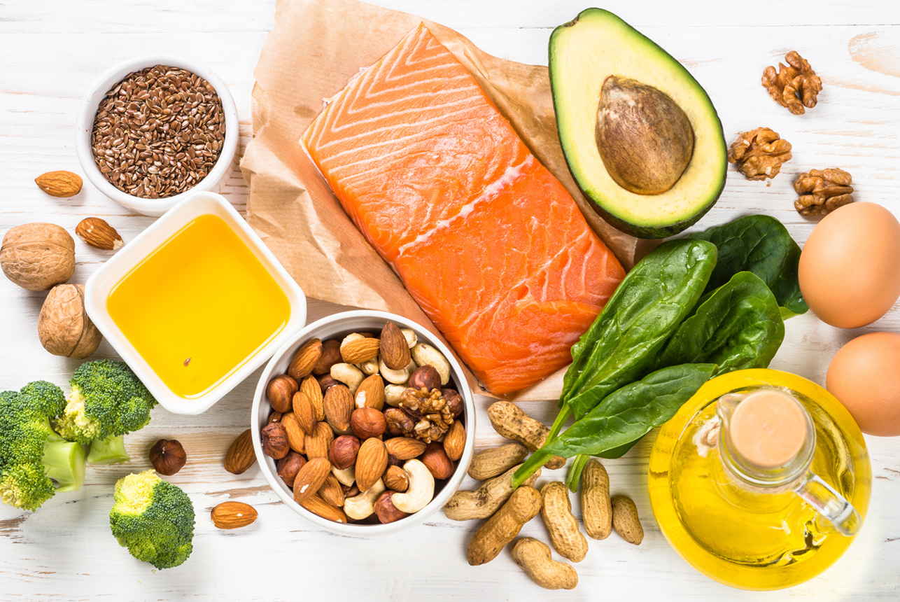 Healthy food on kitchen table, avocado, salmon, oils