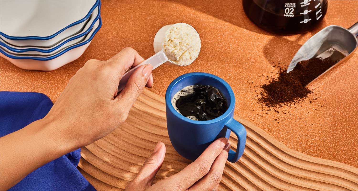 person scooping creamer into coffee